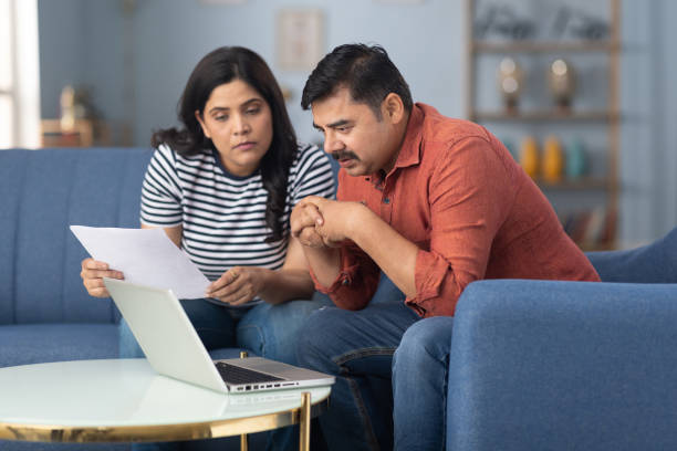happy couple checking documents with using laptop